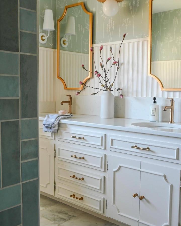 White fluted bathroom wall panels next to brass fixtures and green floral wallpaper from @blairhousedesign. Elegant, textured bathroom wall panel ideas.