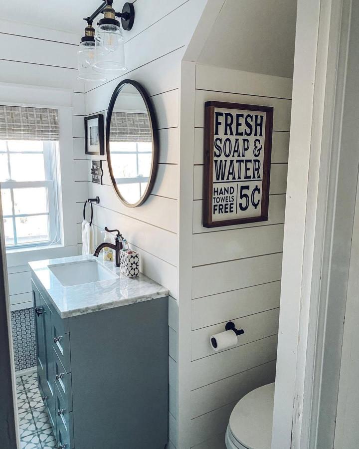 White shiplap bathroom walls from @the_seasoned_home with marble countertop and black mirror frame bathroom wall panel ideas. Bright, cozy, classic.