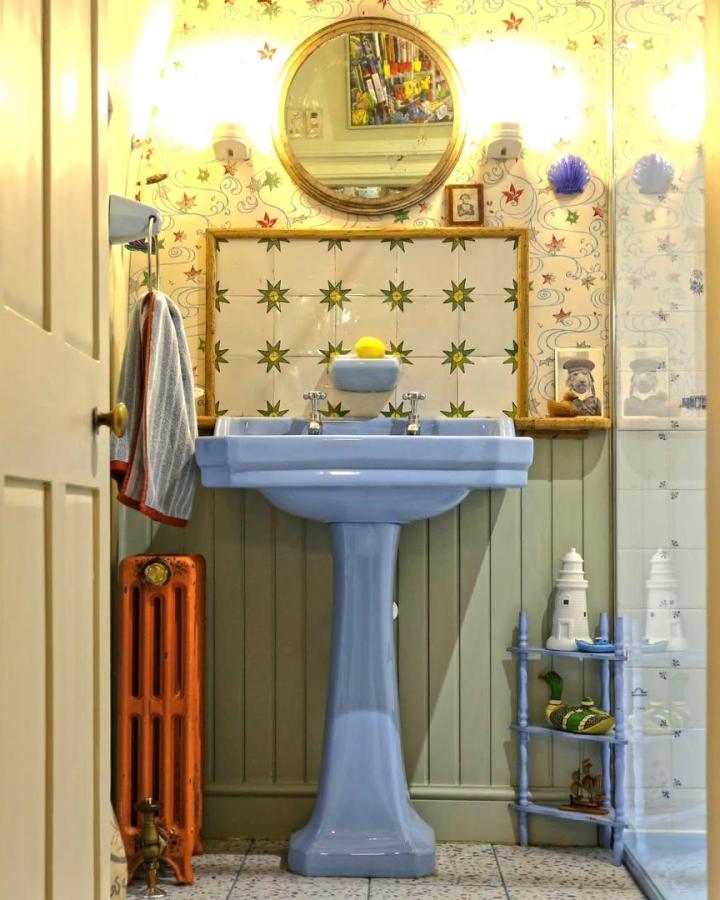 Deco powder blue basin and toilet set with green star tiles in cozy vintage bathroom from @theboldbathroomcompany showcasing blue bathroom decor ideas and charm