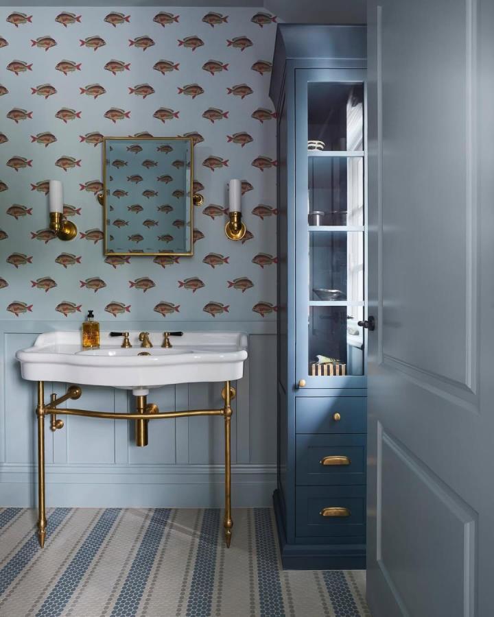 Coastal blue bathroom with fish wallpaper and brass fixtures from @visualcomfort elegant vintage coastal style blue bathroom decor ideas