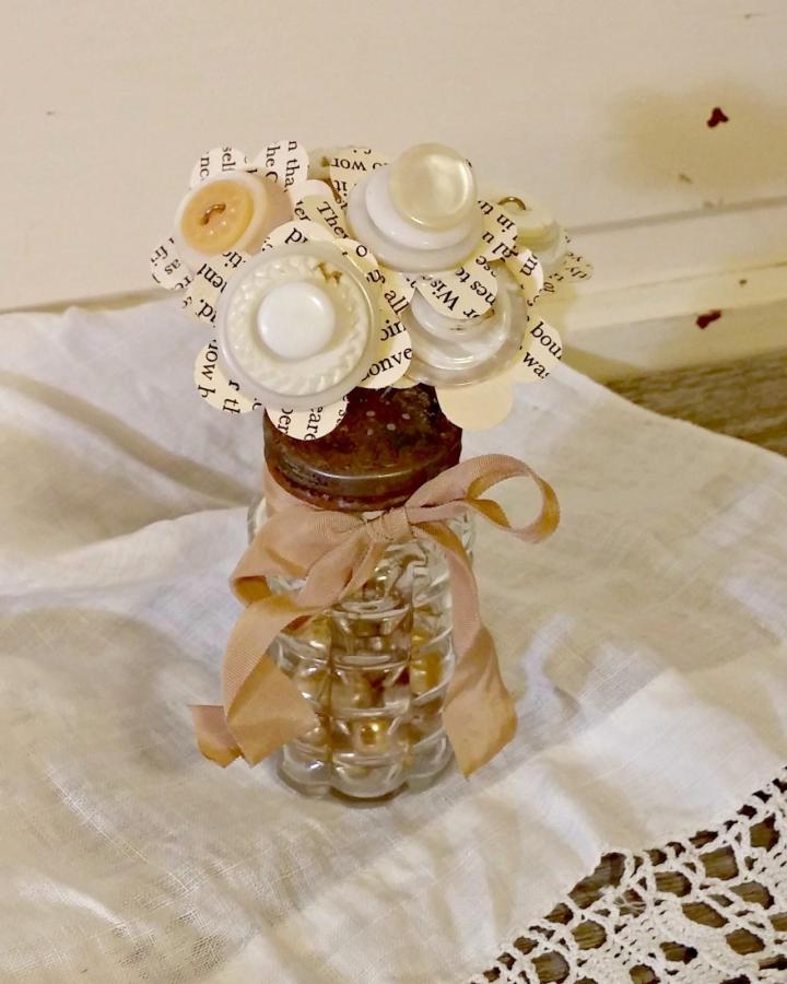 Vintage white and ivory button flower bouquet in glass jar with taupe ribbon from littlevintagecottage. Nostalgic button crafts for adults project.