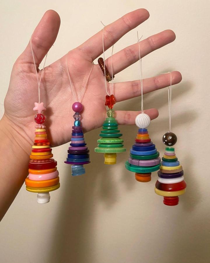 Colorful stacked button tree ornaments from @clay.and.color showing playful button crafts for adults with varied sizes and hues.