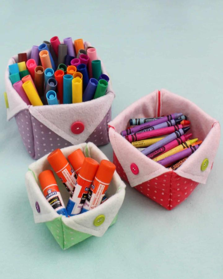 Polka dot felt baskets with colorful buttons holding craft supplies made by gluesticksblog showcasing button crafts for adults organization.
