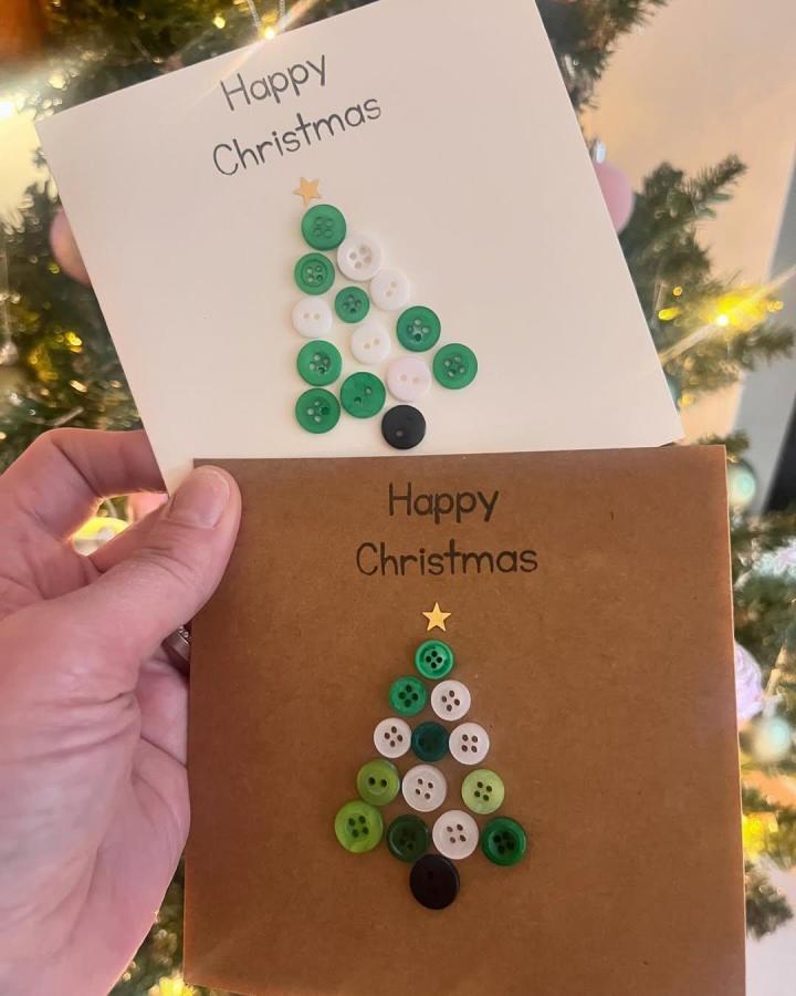Green, white, and black button Christmas tree crafts on cardstock by @lovedbybb. Simple festive button crafts for adults.