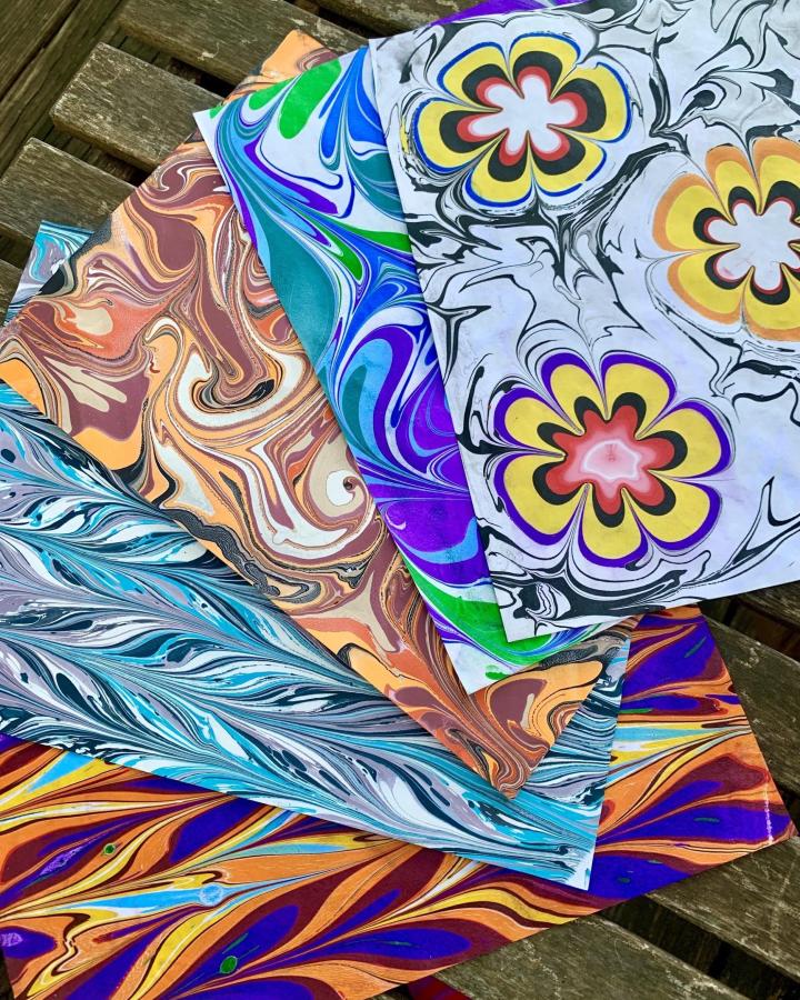 Swirled marbled paper sheets with bright colors from CRAFT: Austin's Craft Room showcasing craft night themes for adults.