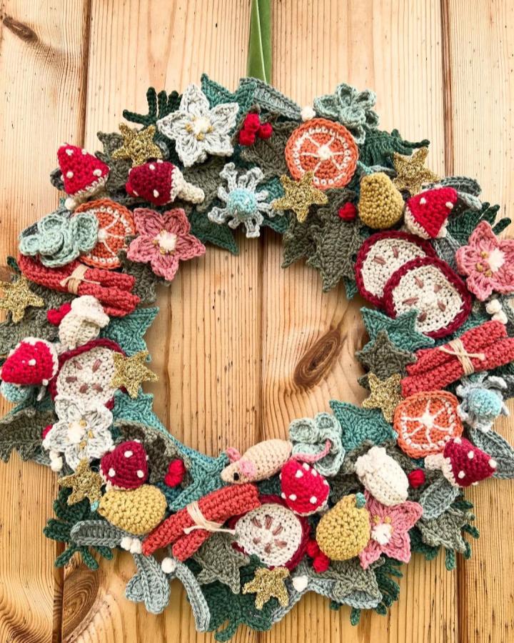 Colorful crochet wreath with mushrooms, stars, leaves, and flowers from @happyhmw. Handmade whimsical crochet wall hanging ideas.
