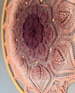 Purple and dusty rose floral crochet wall hanging on wooden hoop from @woolly_fingers. Detailed lacework with bead accents.