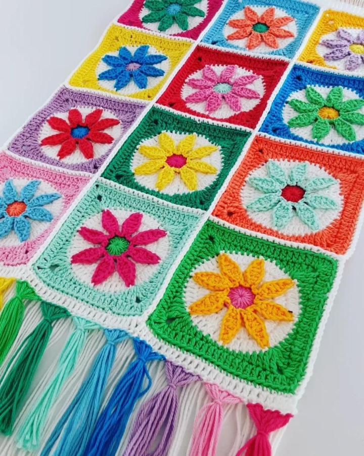 Bright multicolor floral crochet squares wall hanging with pastel tassels from @lovedottycrochet. Handmade cheerful patchwork crochet wall hanging ideas.