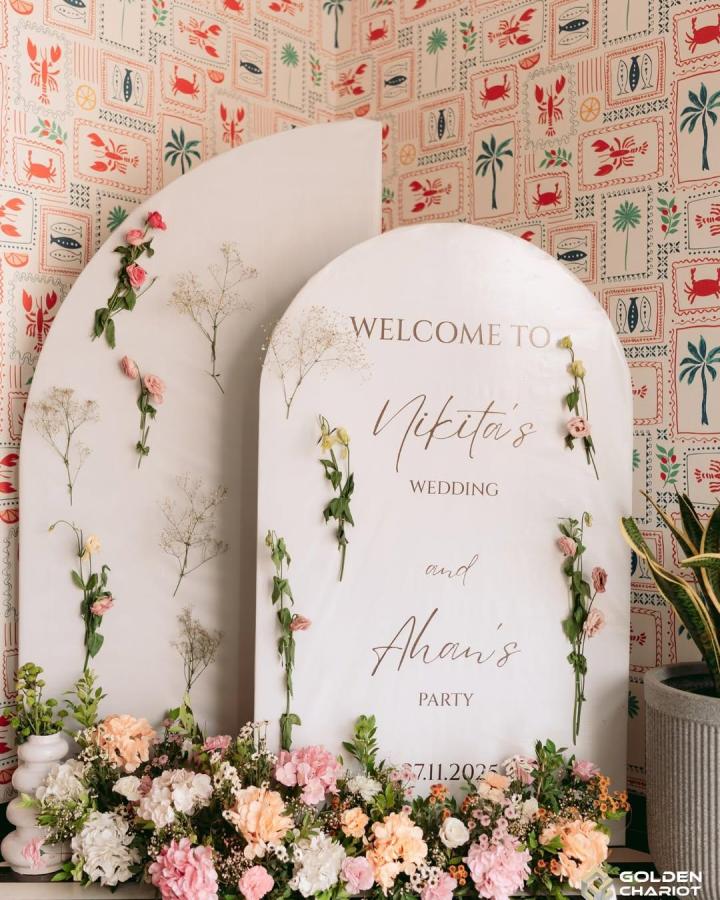 Creamy arched wedding welcome sign decorated with pastel flowers and delicate greenery from @goldenchariot_weddings diy wedding welcome sign ideas floral arrangement.