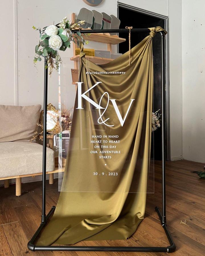 Clear acrylic board with olive draped fabric and white lettering diy wedding welcome sign ideas by Wedding Welcome Signs KL floral accent