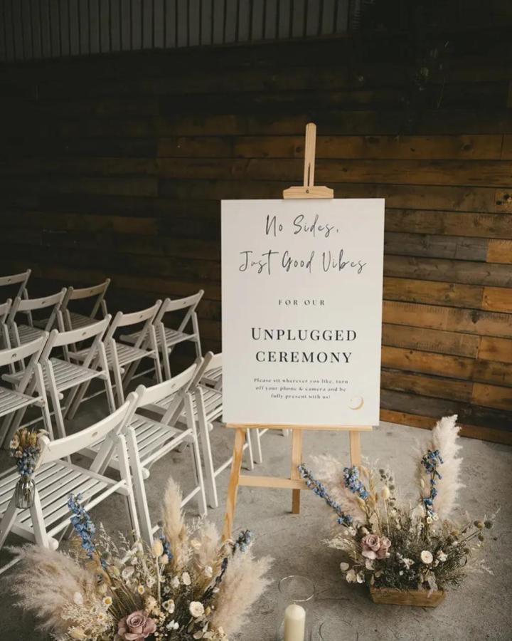 Neutral pampas grass and dried flower arrangements with a minimalist wooden easel sign from One Fab Day for diy wedding welcome sign ideas in a rustic setting