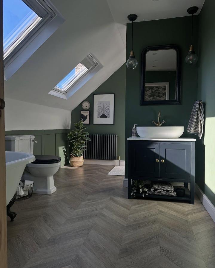 Dark forest green walls with natural wood herringbone floor in bathroom from @love_this_old_house. Cozy and elegant green bathroom decor ideas.