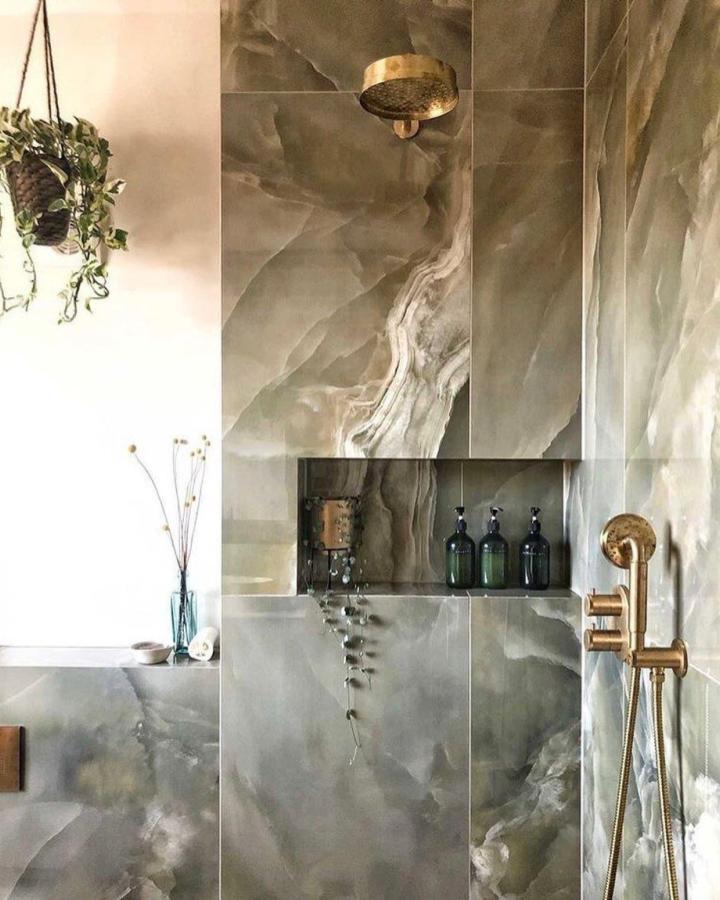 Olive green marble walls with gold fixtures in bathroom from @mandarinstoneofficial featuring green bathroom decor ideas with natural and elegant elements