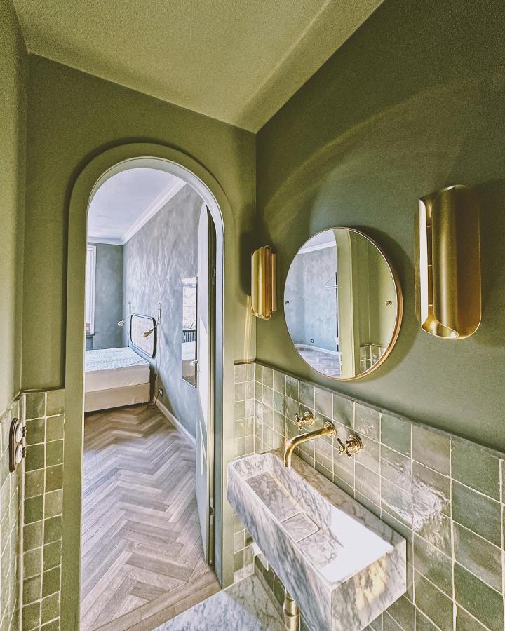 Olive green walls and tiles with marble sink and brass fixtures in a stylish bathroom from @st.oak_apartments green bathroom decor ideas. Elegant and warm.