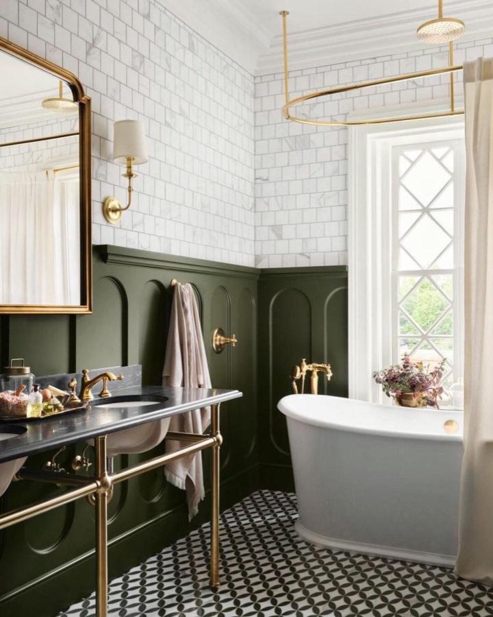 Olive green wainscoting bathroom with gold fixtures and patterned floor tiles from @kathykuohome. Chic green bathroom decor ideas with classic style.