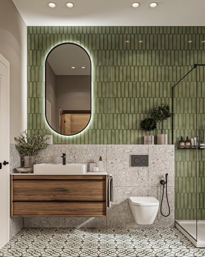 Green glossy vertical tiles with wooden vanity and patterned floor in bathroom from @artelledesign showing green bathroom decor ideas.