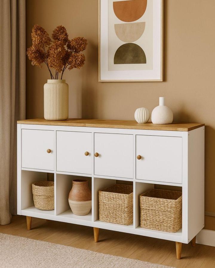 White and honey wood Ikea Kallax bookshelf styling ideas with woven baskets and ceramic vases from @omformo in a warm neutral room.