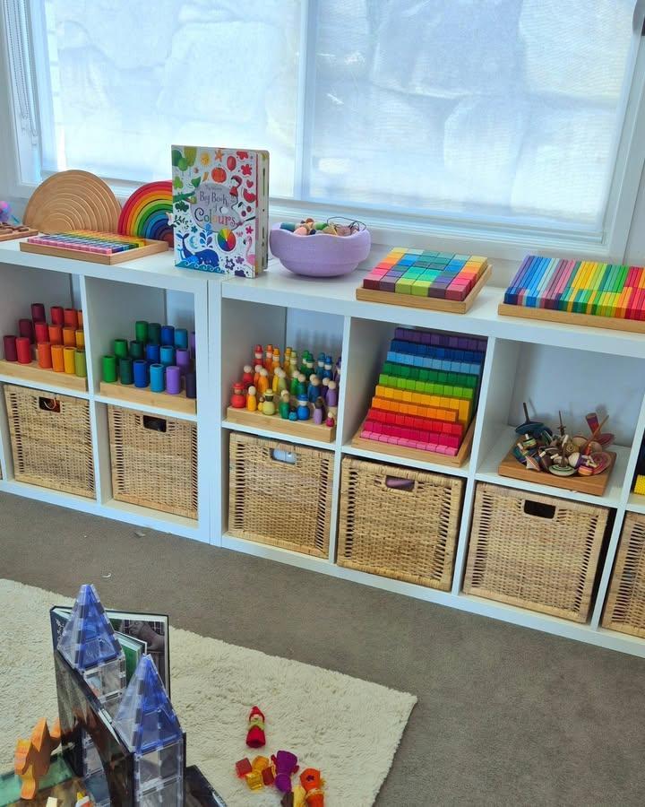 Colorful organized Ikea Kallax bookshelf styling ideas with wicker baskets and rainbow wooden toys in a bright playroom by @maslenmoments.