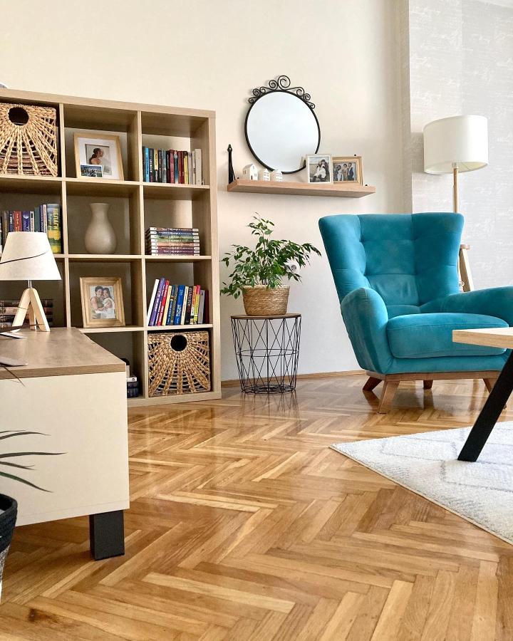 Natural wood ikea kallax bookshelf styling ideas with woven baskets and books in a cozy living room by @po.mom.dom bright and inviting space