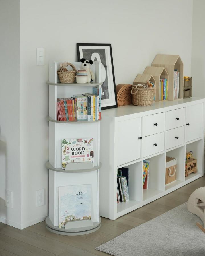 White and gray rounded shelf unit styled with children's books and toys in living room by @moegi.y ikea kallax bookshelf styling ideas