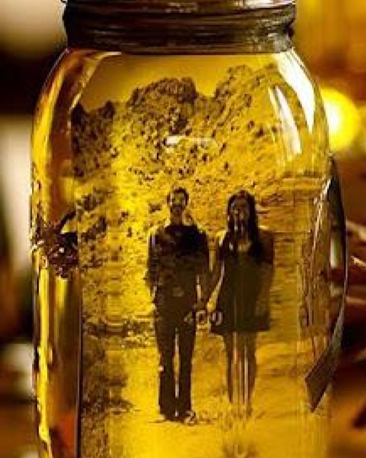 Golden tinted vintage photo mason jar craft with dried lavender and used vegetable oil from Disha Doshi Shah glowing softly indoors vintage style craft.