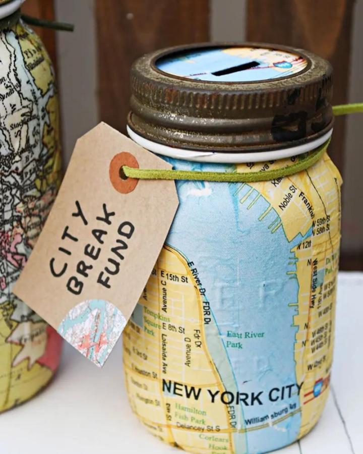 Vintage map-covered Mason jar coin bank from Pillar Box Blue with rustic lid and tag for mason jar crafts for adults.