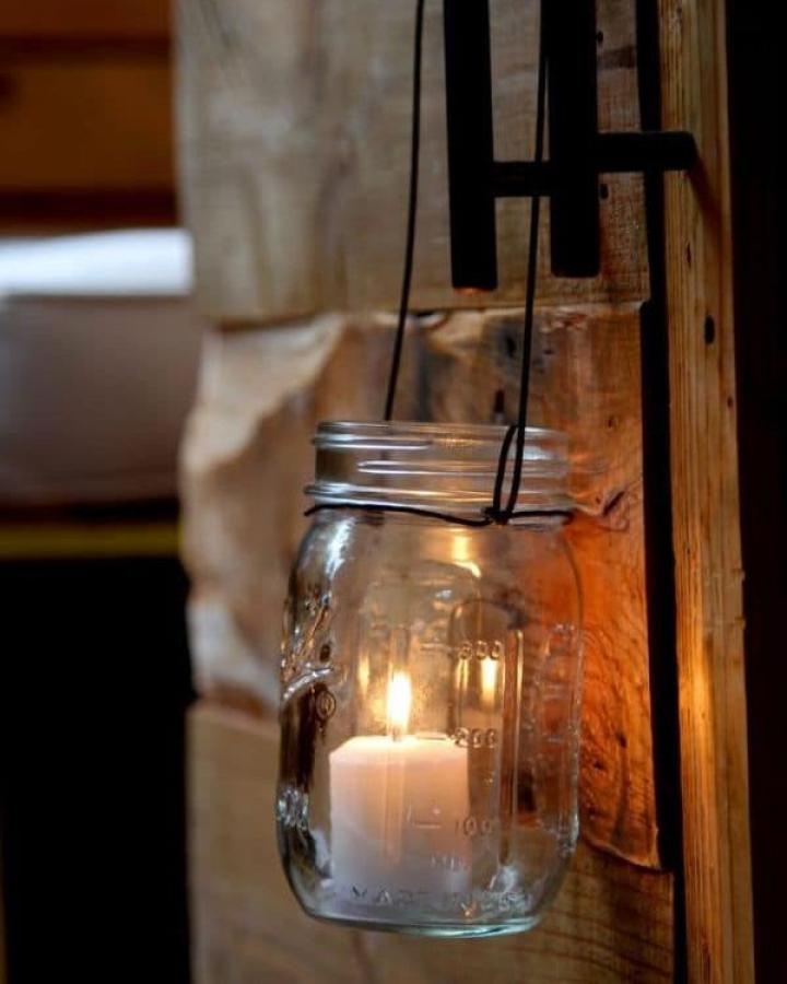 Clear glass hanging candle jar lantern with black wire from A Piece of Rainbow. Rustic cozy lighting mason jar crafts for adults.