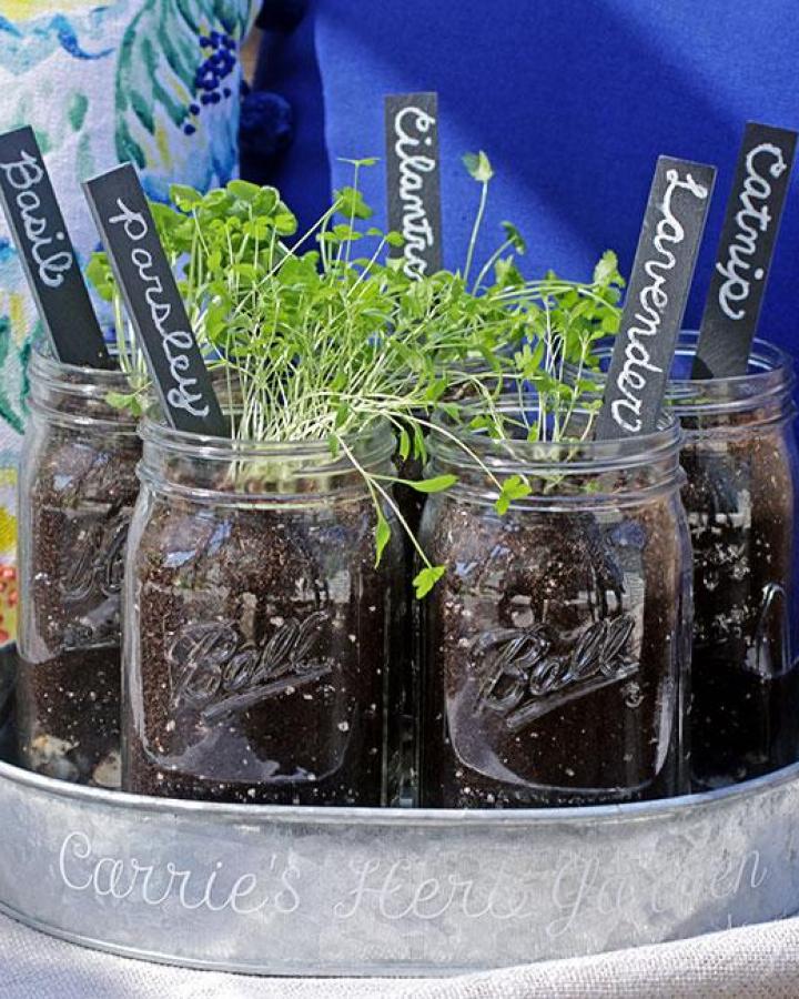 Green mason jar herb garden with chalkboard labels from Curly Crafty Mom. Rustic and personalized indoor planting craft.