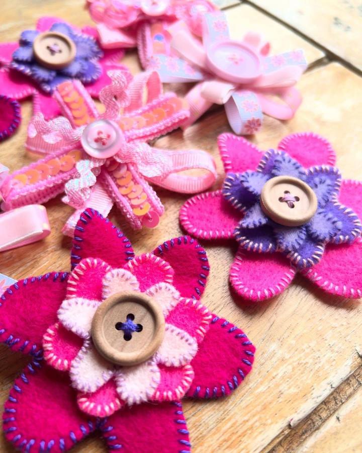 bright pink and purple felt flower pins from @outdoorsyandcreative. mindful crafts for beginners with hand-stitched details and wooden buttons