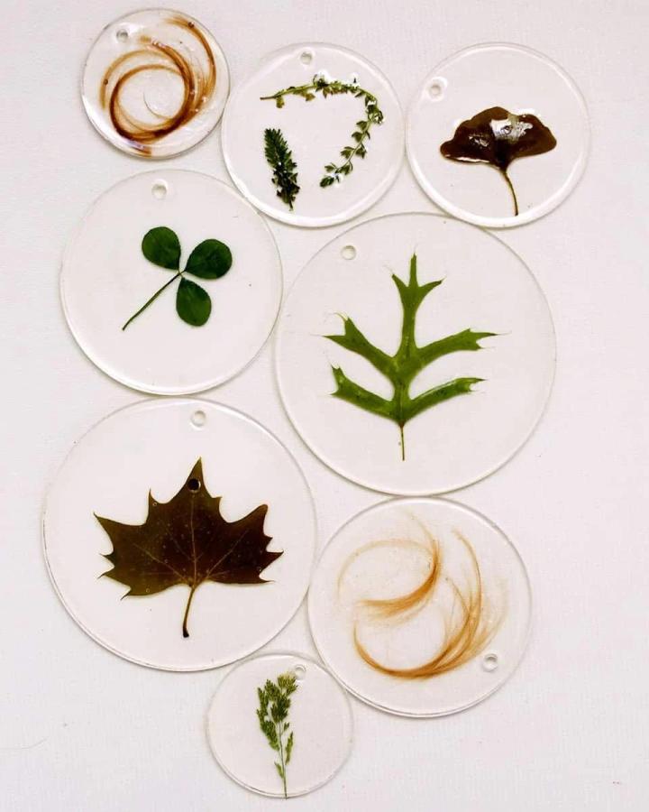 Pressed leaves and natural elements embedded in clear resin discs from abeautifulmess. A calming and creative mindful crafts for beginners project.