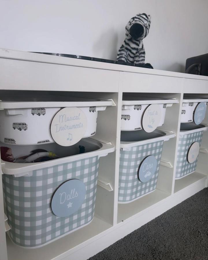 Soft blue gingham check storage bins in nursery shelving by @geoandarlox showcasing ikea nursery storage ideas and toy organization.