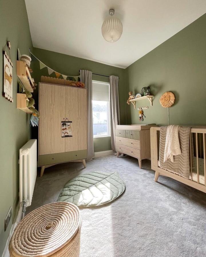 olive green nursery with natural wood Ikea nursery storage ideas from @atnumberfourteen_ featuring soft textures and woven baskets for organization