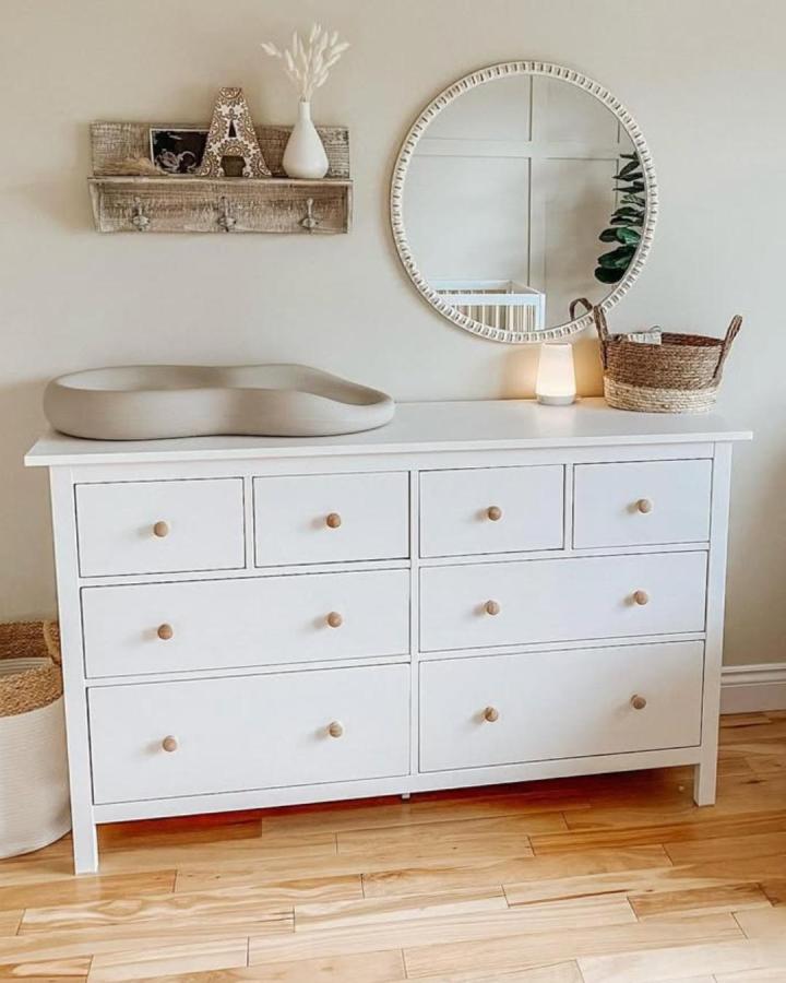 White dresser with natural wood knobs and woven basket for ikea nursery storage ideas by @taryn.elliottt. Simple and warm nursery storage.