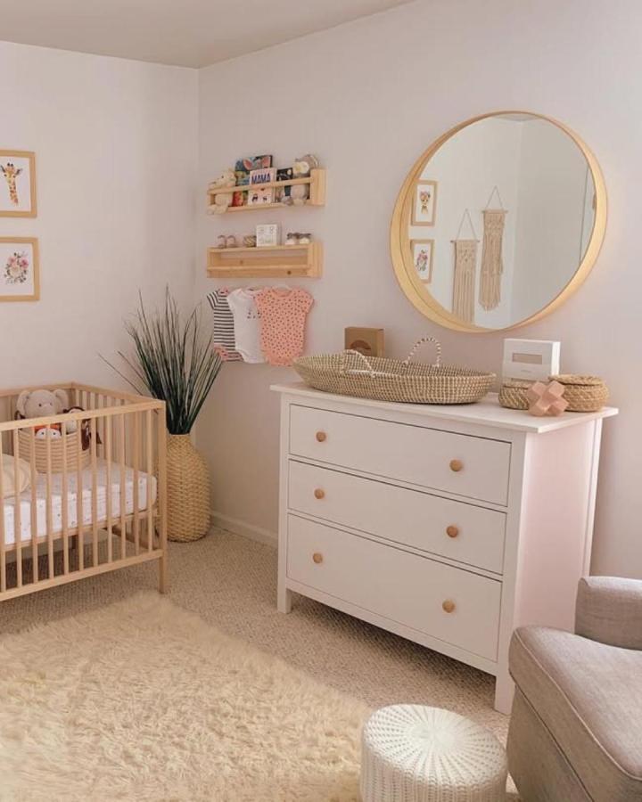 Natural wood shelves and white dresser in cozy nursery by @thediypharmacist featuring ikea nursery storage ideas and woven baskets.