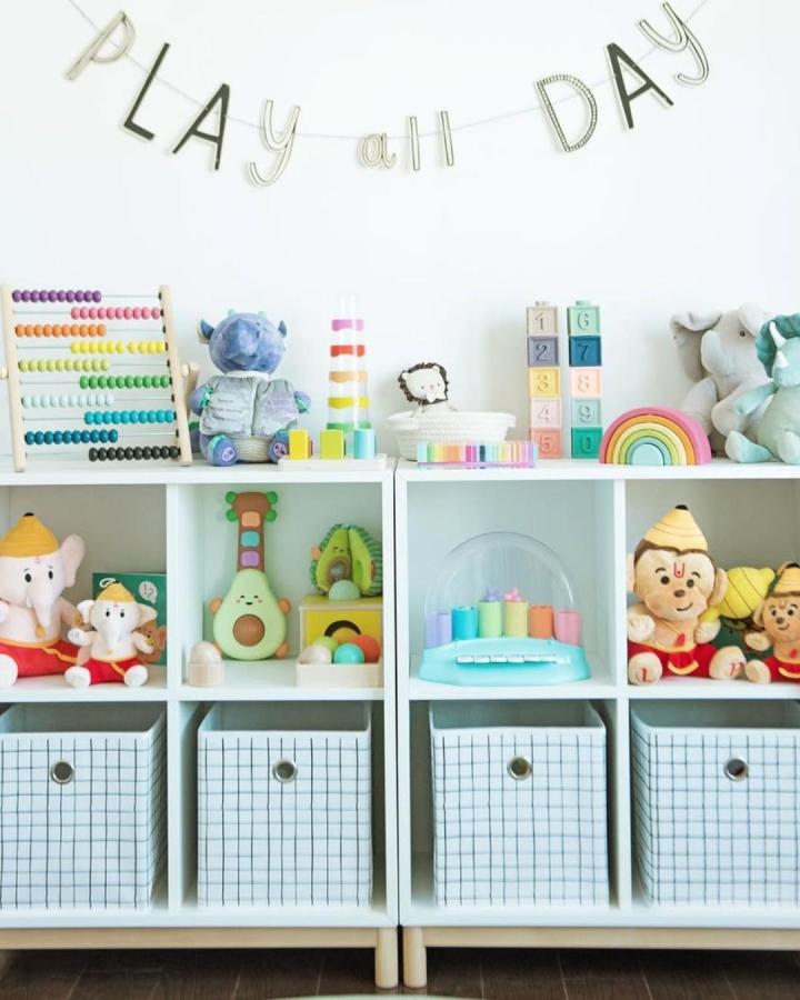 white ikea kallax shelves with pastel toys and checkered fabric storage bins in a nursery by @julie7385 playful and clean ikea nursery storage ideas setup