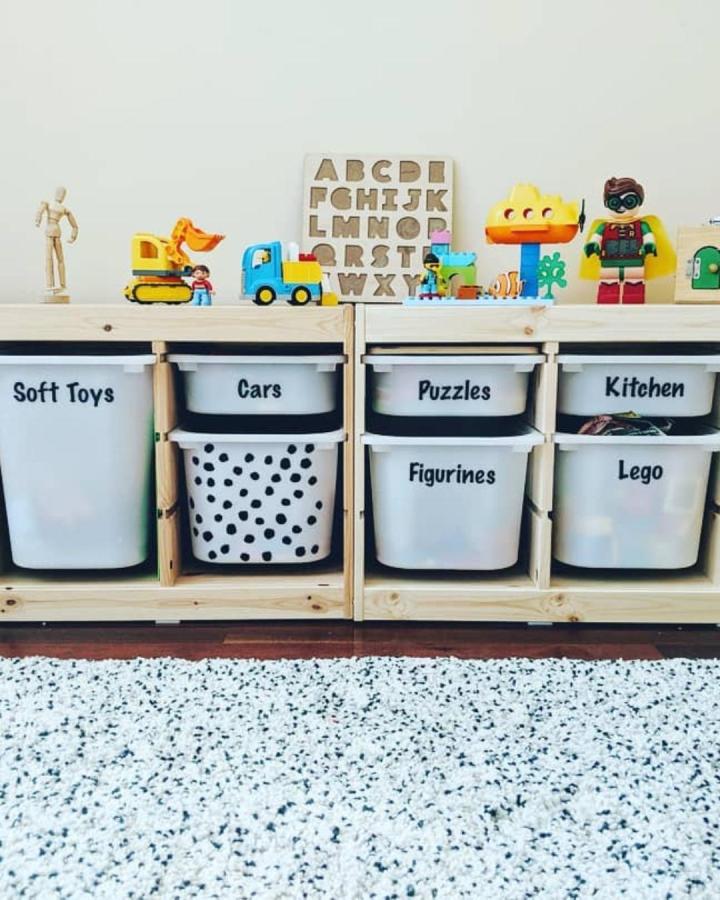 white Ikea Trofast toy storage bins with handwritten labels in natural pine frame nursery from @overhaulmychaos neat and organized ikea nursery storage ideas setup