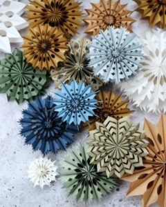 Multicolored cutout paper rosettes from @klickerkram. Intricate designs perfect for paper crafts for adults.