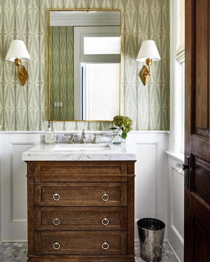 Olive green geometric wallpaper in small powder room by mikellriceinteriors. Elegant pattern with wooden vanity and marble top.