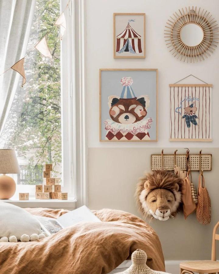 warm muted tones circus nursery ideas wall art frames and natural details from @mabelandfox cozy and playful nursery corner with lion head toy hanging