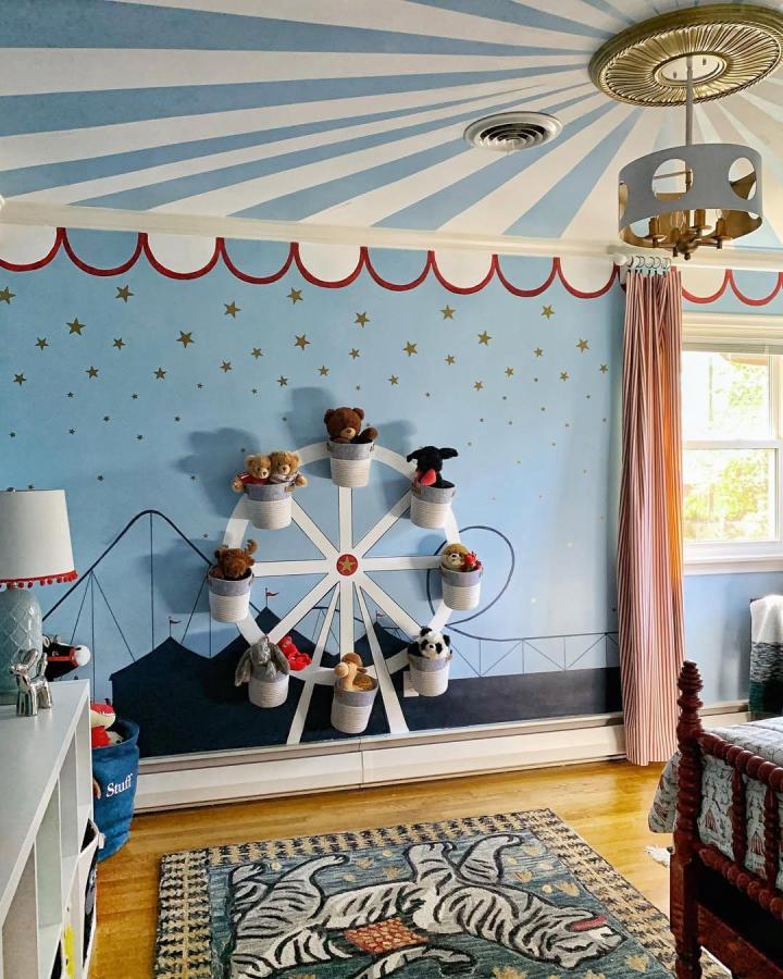 Light blue circus nursery ideas room with Ferris wheel toy storage and starry carnival mural from @blueorchidliving. Cheerful and whimsical.