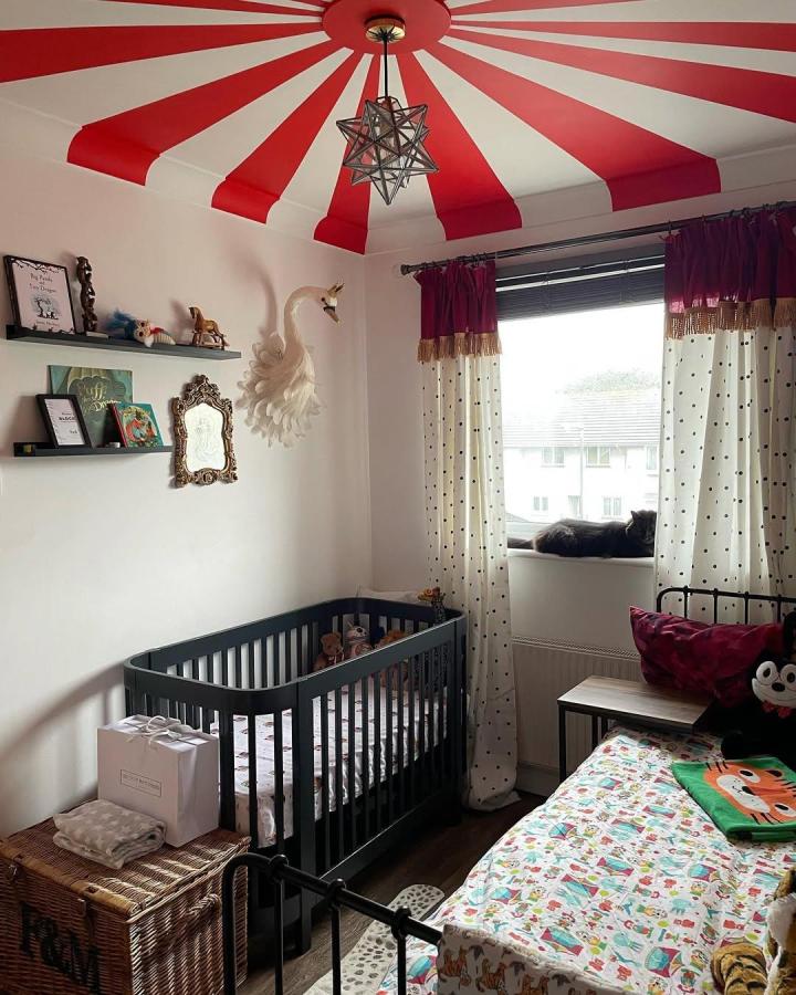 red and white striped ceiling and polka dot curtains in circus nursery ideas by @diamondsandfoes playful, cozy room with vintage flair and modern crib