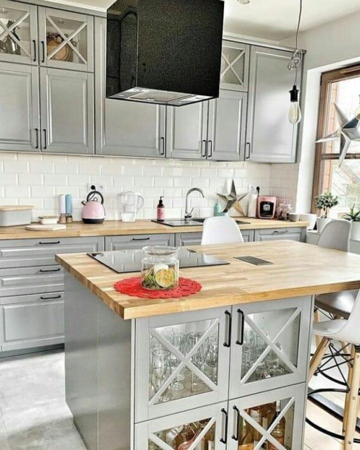 Gray kitchen island with glass doors and wood countertop from @ikea_kitchen_design showing stylish storage and modern farmhouse vibe.