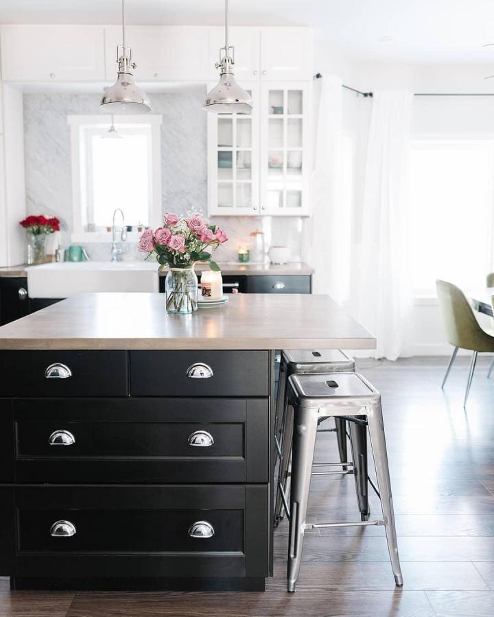 Black kitchen island with polished metal bar stools and silver drawer handles in a bright modern kitchen by @cozydiyhome showcasing urban chic style.