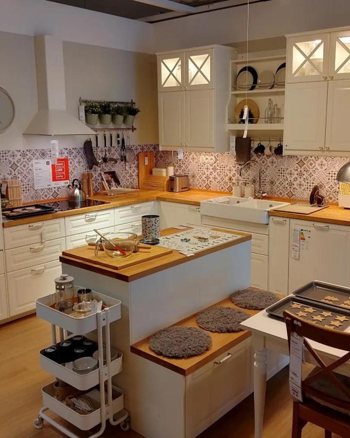 Cream and wood kitchen island with cushioned bench seating and patterned backsplash by @ikea_kitchen_design showing a neat dining nook and storage combo.
