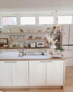 White kitchen island with wooden countertop and simple floral decor from @aco__m.a__. Bright, cozy, and minimal modern style.