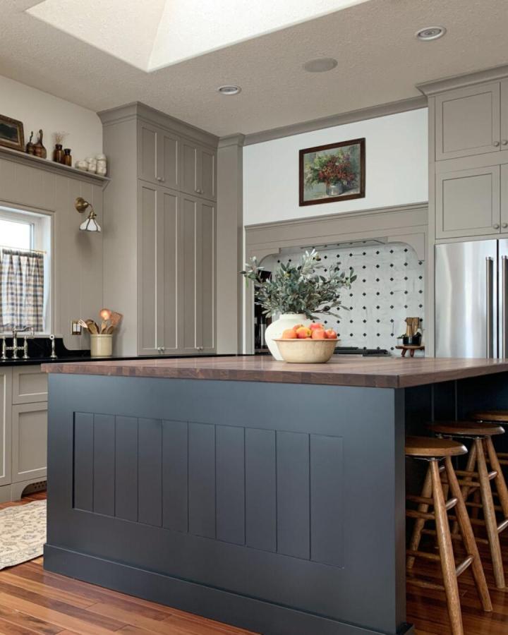 Navy blue kitchen island with walnut top and wooden stools from Erin Zubot Design featuring ikea kitchen island hacks.