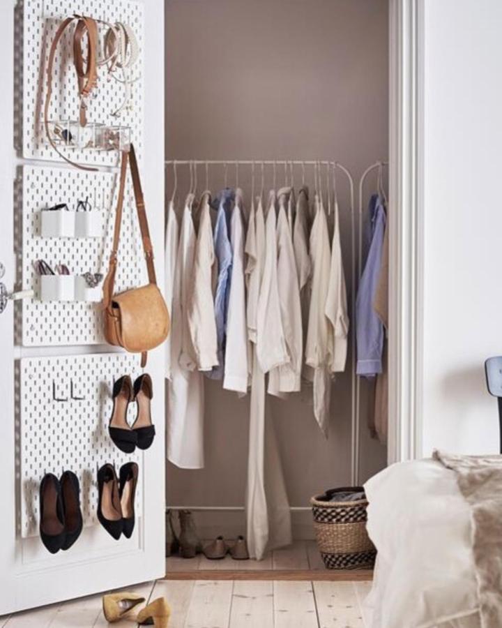 white pegboard door organizer and clothing rack from @ikeasverige ikea skadis craft room ideas with shoes and bags neatly arranged on hooks and shelves