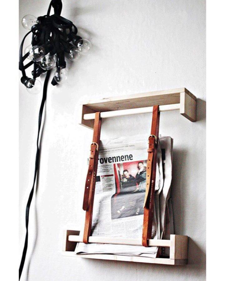 Light pine wood and brown leather spice rack storage on white wall by @house_of_dreamers displaying minimalist rustic kitchen organization idea.