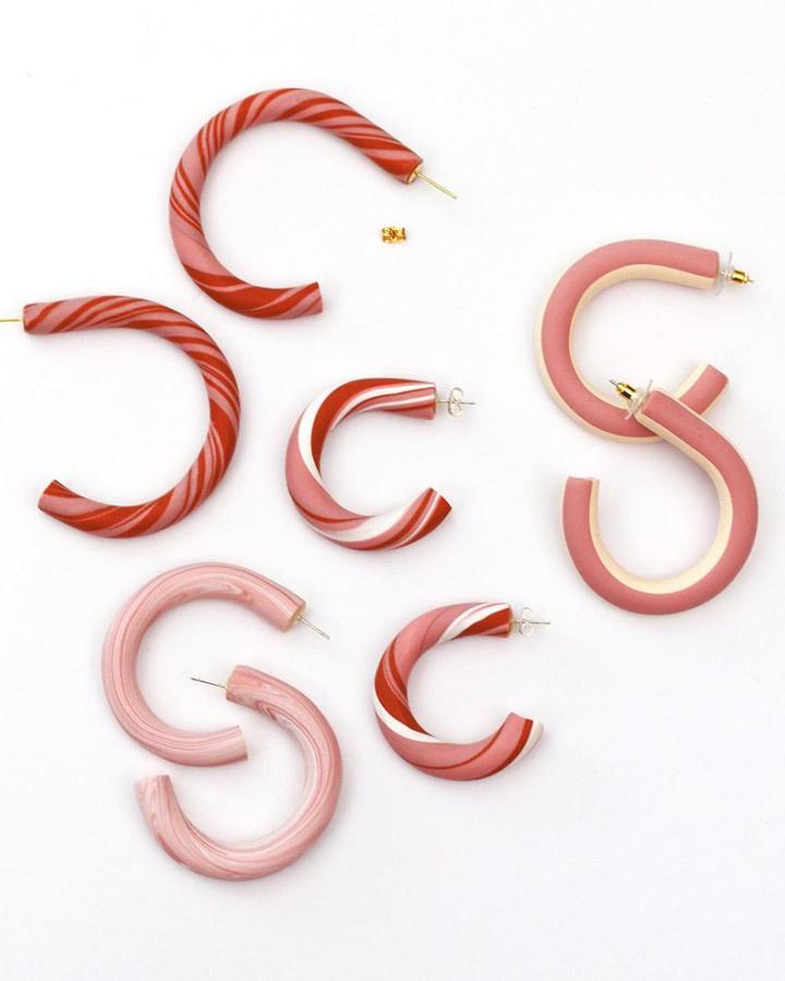 Pink and red swirled polymer clay hoop earrings in various sizes from persia lou. Bold patterns and smooth matte finish hoops for stylish accessories.