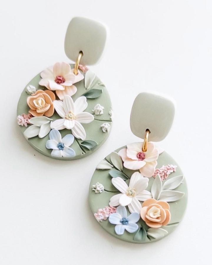 Soft sage green round earrings with pastel floral details and cream square studs from @sugarmoonclay. Beautiful polymer clay earrings ideas with delicate flower accents.